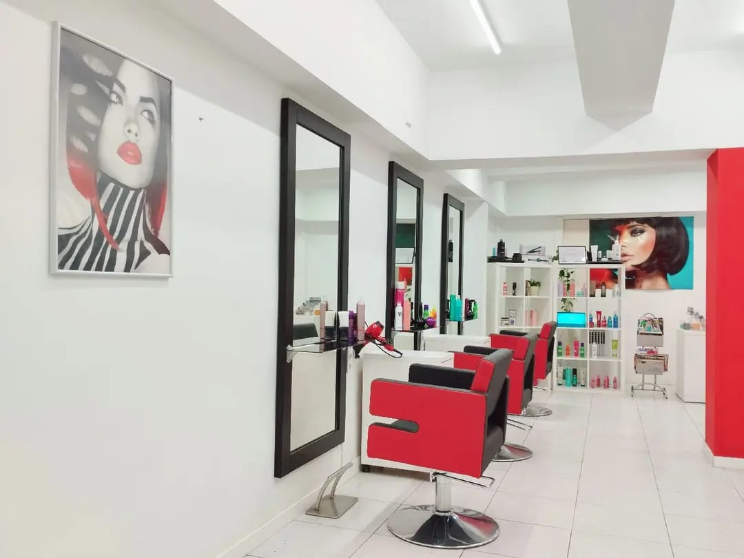 Interior del salón Dycon Stylist con sillas de trabajo rojas y negras